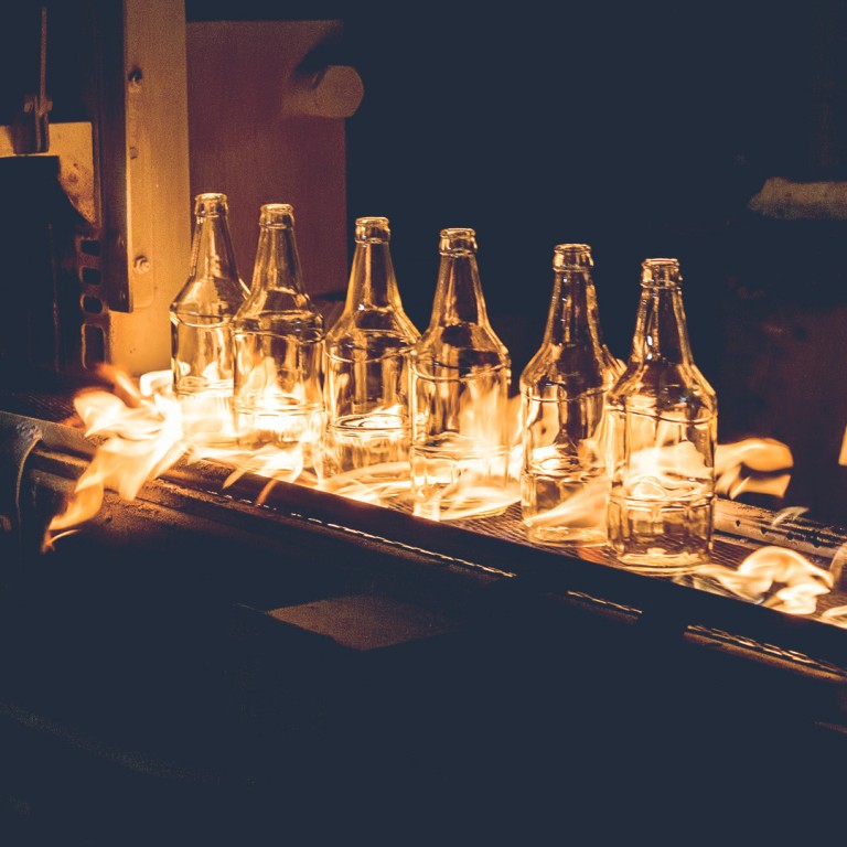 Glowing glass bottles at the production line